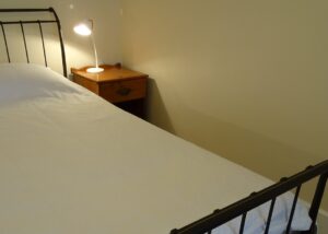 Loft bedroom with reading lamp at White & Red Rose Cottages