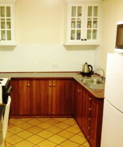 Cottage kitchenette with white cupboards at White & Red Rose Cottages