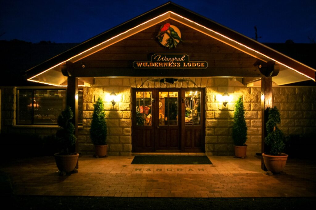 Stone entrance of Wangrah Wilderness Lodge lit up at night