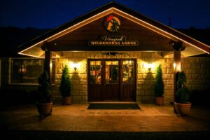 Stone entrance of Wangrah Wilderness Lodge lit up at night