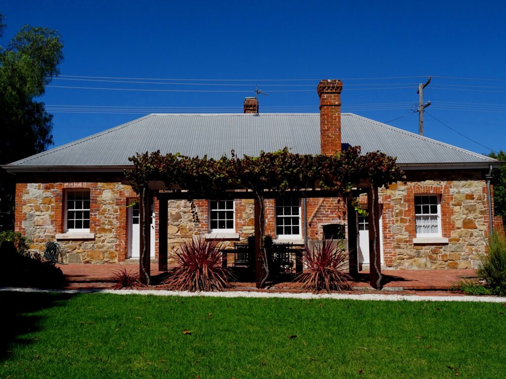 White and Red Rose stone cottages under a vine-covered pergola, Tenterfield