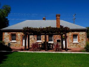 White and Red Rose stone cottages under a vine-covered pergola, Tenterfield