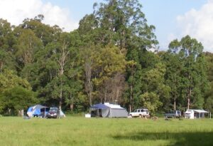 Tents and campers set up on the grass flat at Lanikai Camping Ground