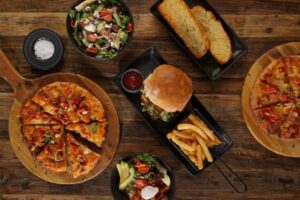 Pizzas, burgers and sides served on timber boards