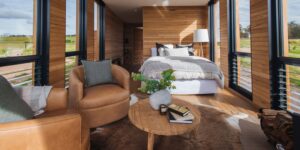Bedroom with leather armchairs and floor-to-ceiling windows in the Gabarraa cabin