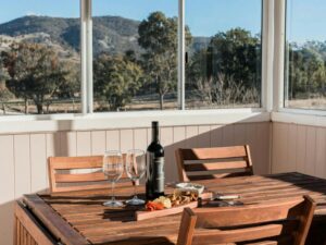 Sunroom dining table with wine and grazing board at Sunday at Mirumiru