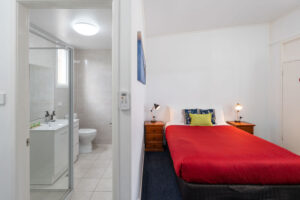 Motel room with red-covered bed and ensuite at the Royal Motel Tenterfield