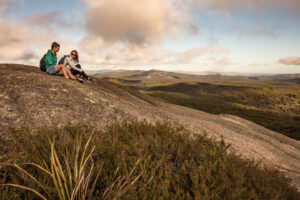 Couple sitting on the granite slope of Bald Rock at sunset