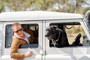 Man and his black dog leaning out of a white van on the Wine and Wilderness Trail