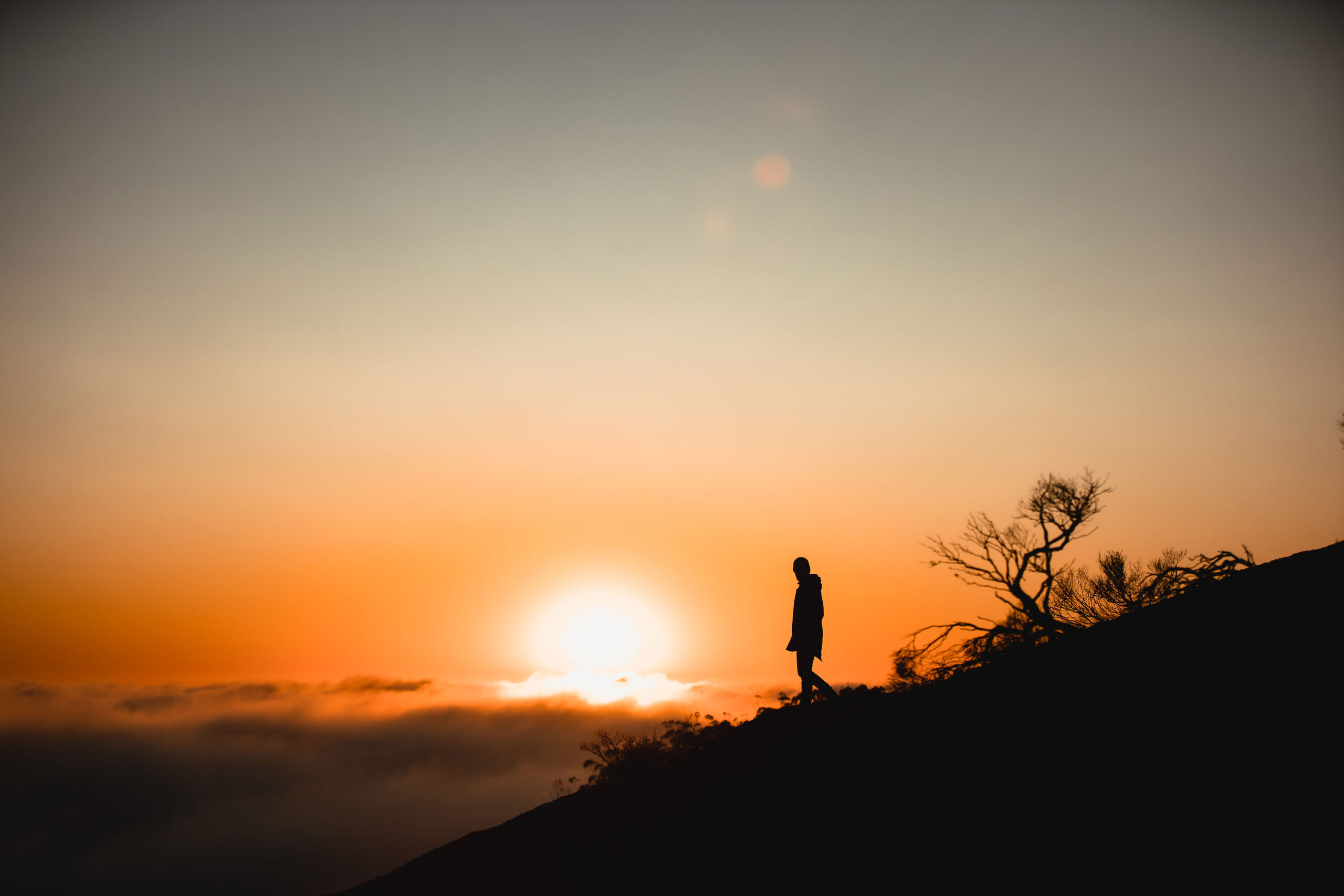 Hiker silhouetted against the sunrise on a Tenterfield high country ridge