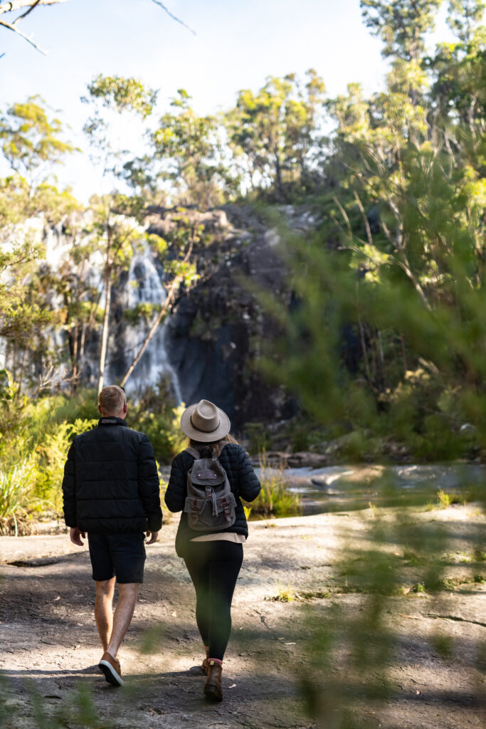 Couple walking towards the waterfall at Boonoo Boonoo