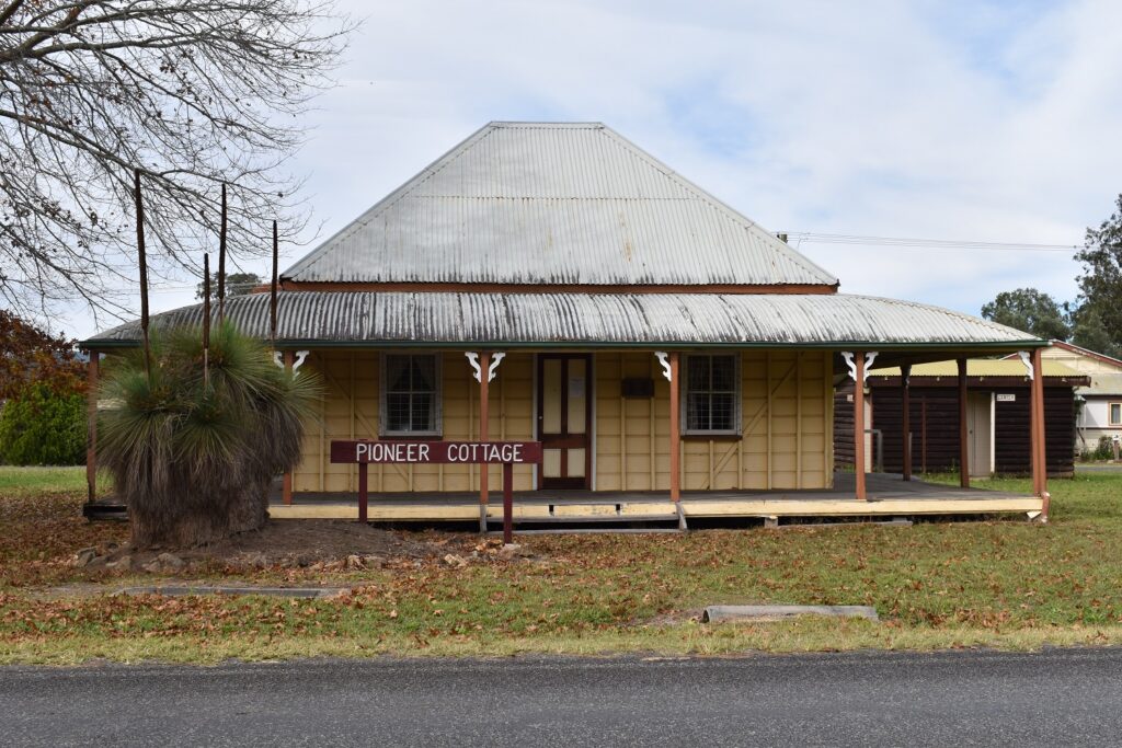 Old pioneer cottage with grass trees near the Border Mountains