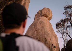Hiker looking up at balancing granite boulders in Girraween National Park
